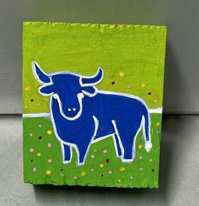 tiny painting of a bull in a field